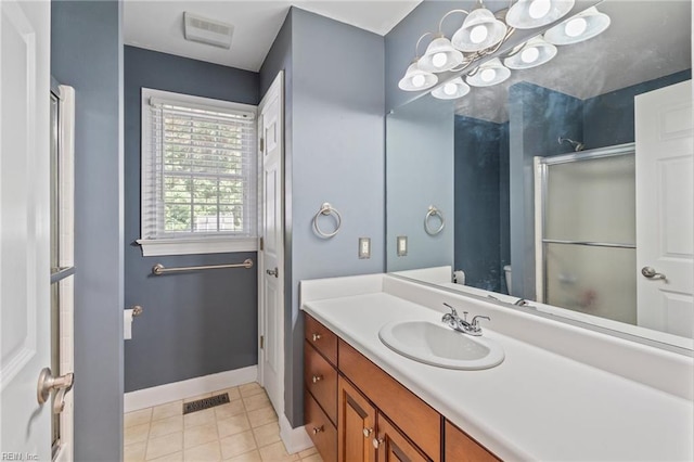 bathroom with a shower with door, tile patterned floors, and vanity