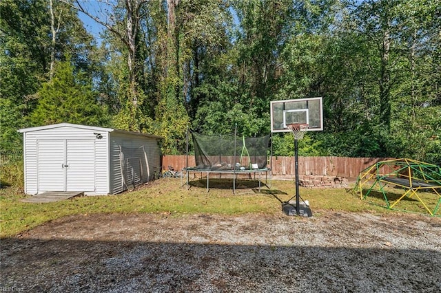 view of yard featuring a trampoline and a shed