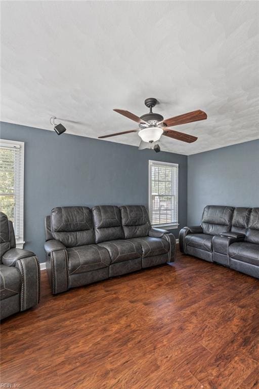 living room featuring ceiling fan and dark hardwood / wood-style floors