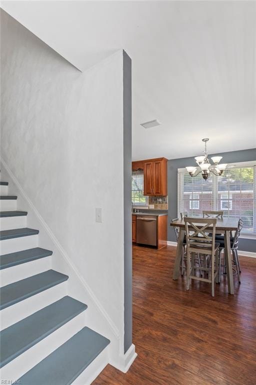 unfurnished dining area with an inviting chandelier and dark hardwood / wood-style flooring