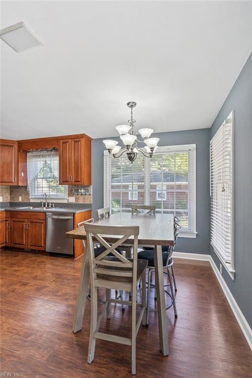 dining area with dark hardwood / wood-style floors, a notable chandelier, and sink