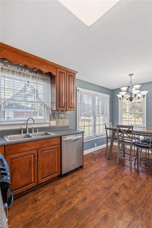 kitchen featuring dark wood-type flooring, an inviting chandelier, sink, and stainless steel appliances