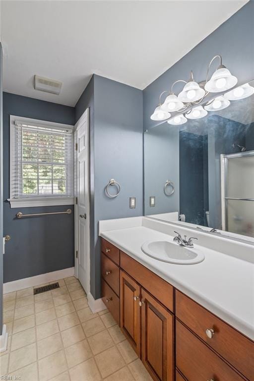 bathroom with vanity, a shower with door, and tile patterned floors