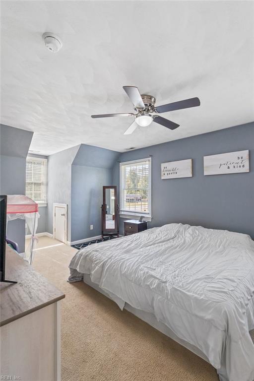 bedroom featuring ceiling fan, light carpet, and vaulted ceiling