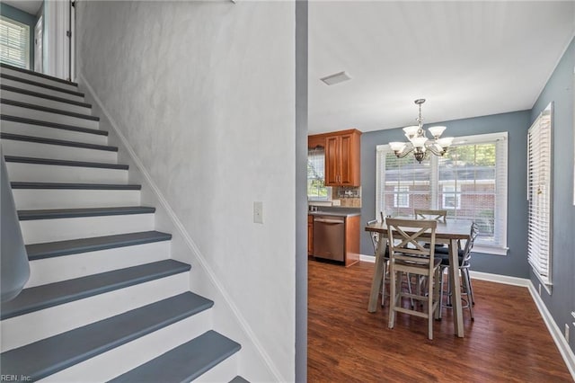 stairway featuring a notable chandelier and hardwood / wood-style flooring