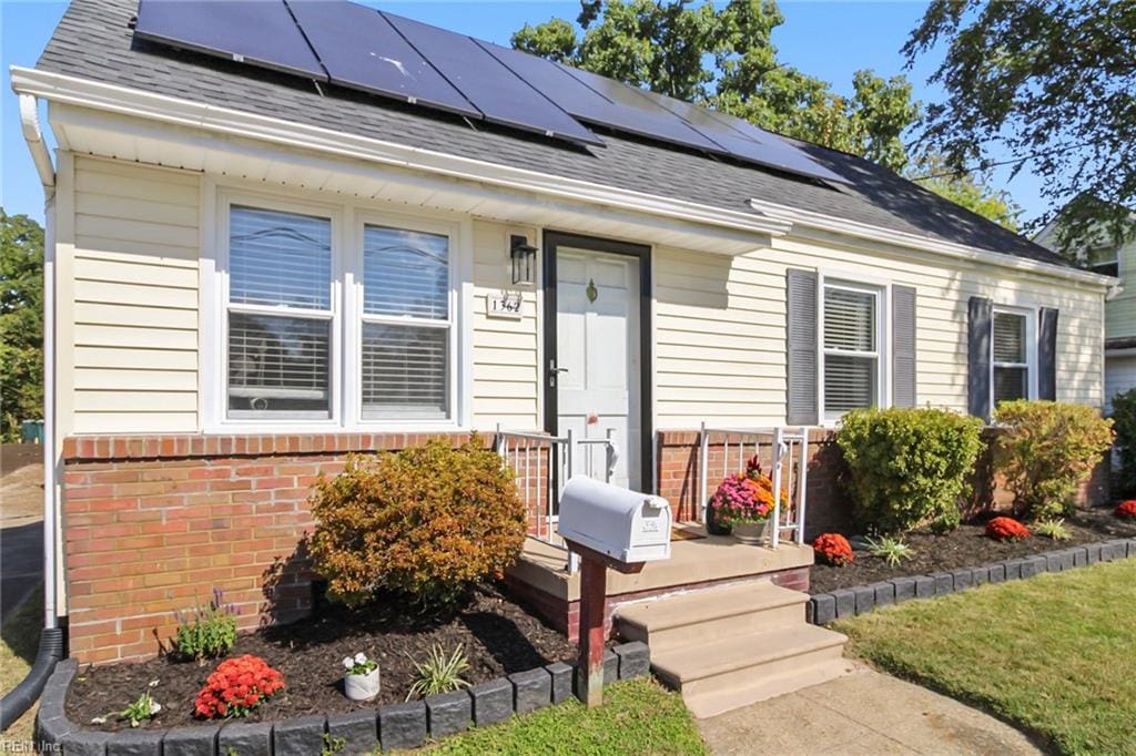 single story home featuring solar panels