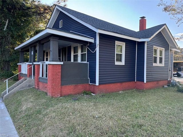 view of home's exterior featuring a porch and a yard