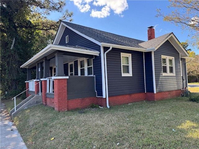 view of side of home featuring a lawn and a porch