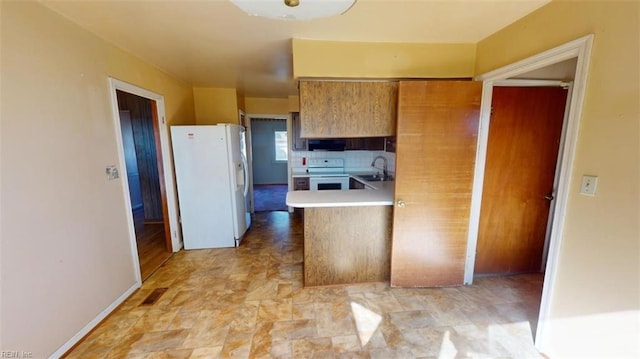 kitchen with sink, decorative backsplash, kitchen peninsula, and white appliances