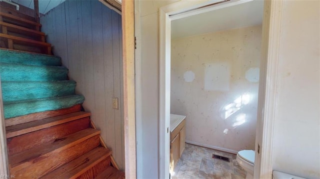 stairs featuring wooden walls