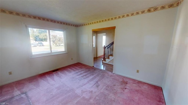 unfurnished room featuring light carpet