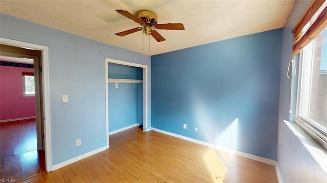 unfurnished bedroom with light hardwood / wood-style flooring, a closet, and ceiling fan