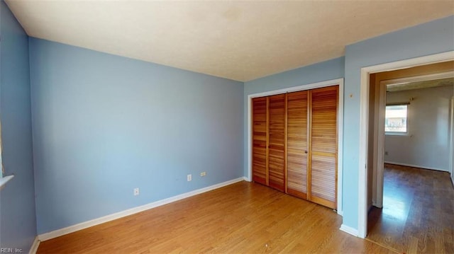 unfurnished bedroom featuring a closet and light hardwood / wood-style flooring