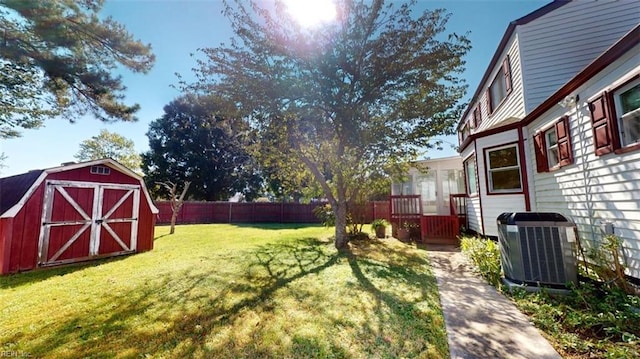 view of yard featuring a storage unit and central AC