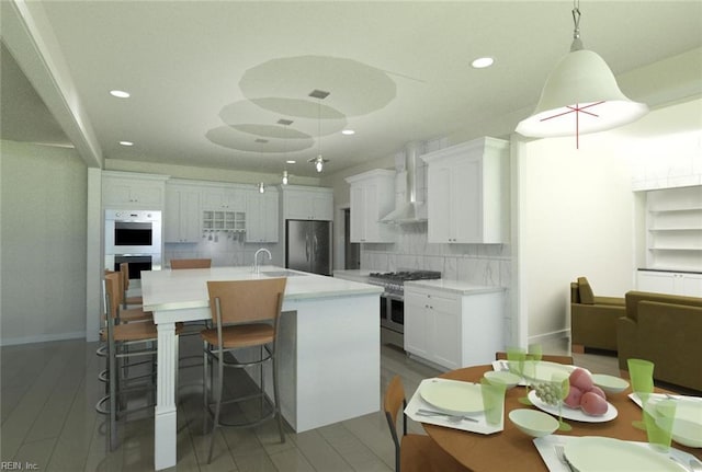 kitchen with decorative backsplash, a kitchen island with sink, wall chimney exhaust hood, stainless steel appliances, and pendant lighting