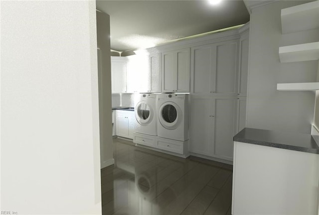 laundry area with washing machine and dryer and cabinets