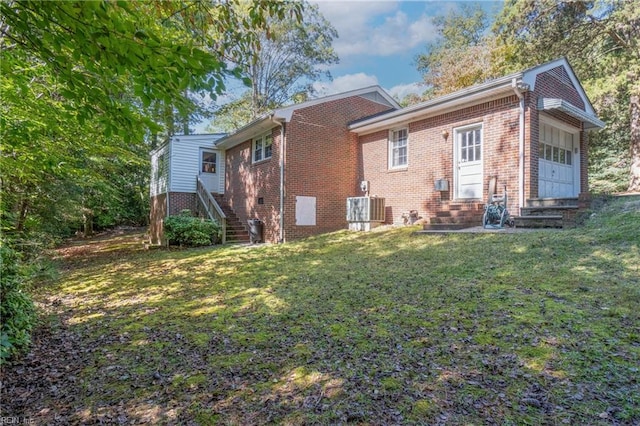 back of house with a yard and central AC