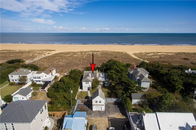 birds eye view of property with a water view and a beach view