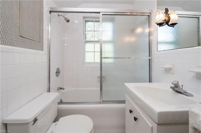 full bathroom featuring tile walls, vanity, enclosed tub / shower combo, and toilet