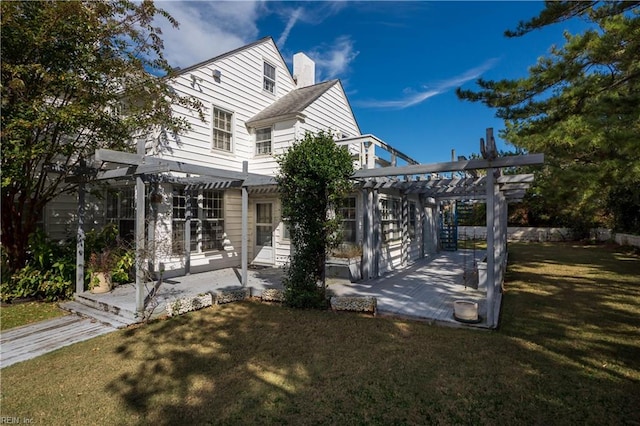 rear view of house with a patio area, a lawn, and a pergola