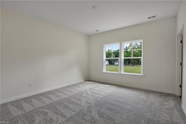 unfurnished room featuring visible vents, carpet, and baseboards