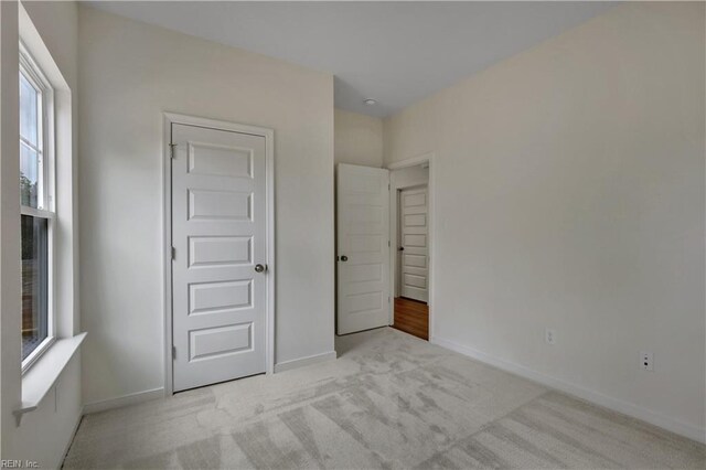 unfurnished bedroom featuring carpet flooring and baseboards