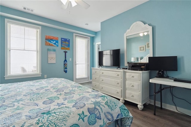 bedroom with ceiling fan, dark wood-type flooring, and multiple windows