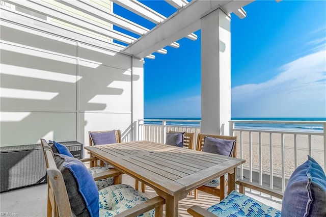 balcony with a water view, a pergola, and a beach view