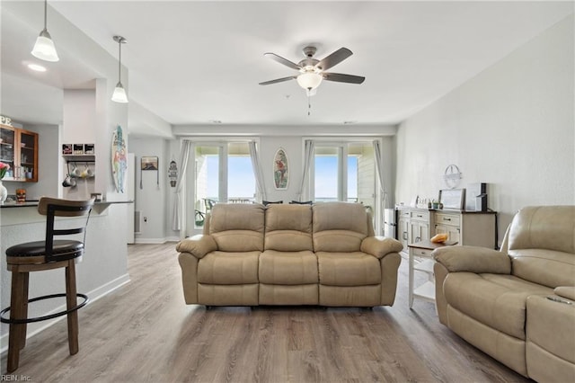 living room featuring ceiling fan and hardwood / wood-style floors