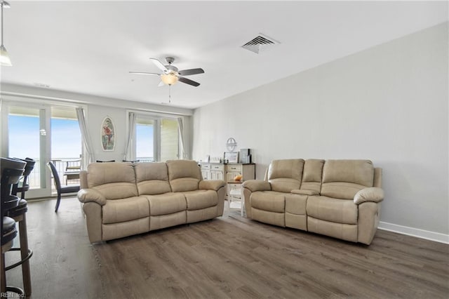 living room featuring ceiling fan and dark hardwood / wood-style flooring