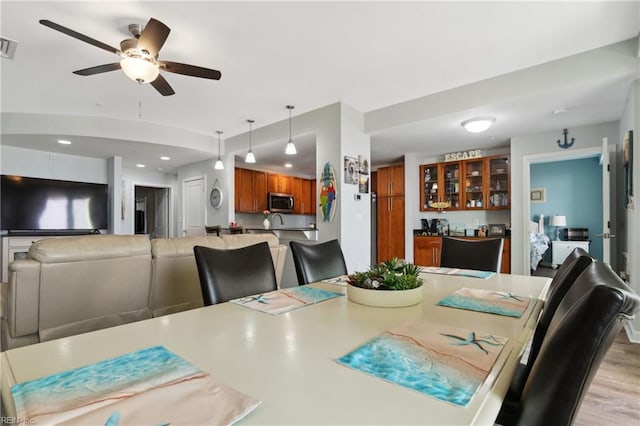 dining area with ceiling fan and light hardwood / wood-style flooring