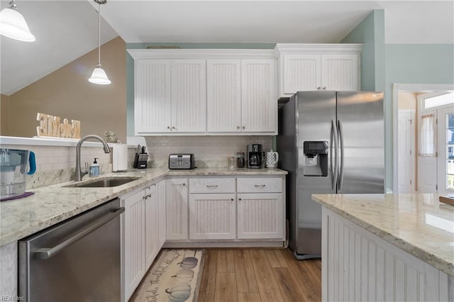 kitchen featuring decorative backsplash, stainless steel appliances, sink, white cabinetry, and light hardwood / wood-style flooring