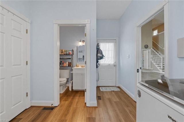 bathroom featuring wood-type flooring, vanity, and toilet