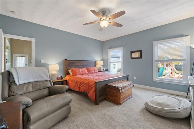 bedroom with light colored carpet, multiple windows, and ceiling fan