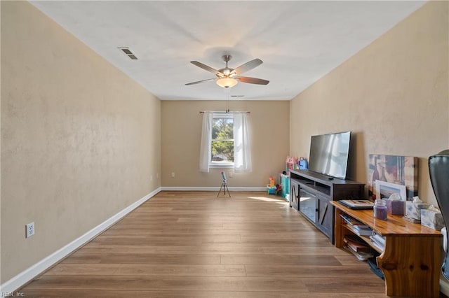 living room with wood-type flooring and ceiling fan