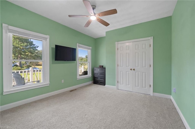 unfurnished bedroom with ceiling fan, a closet, and carpet