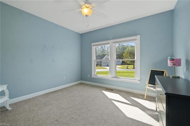 carpeted spare room with ceiling fan