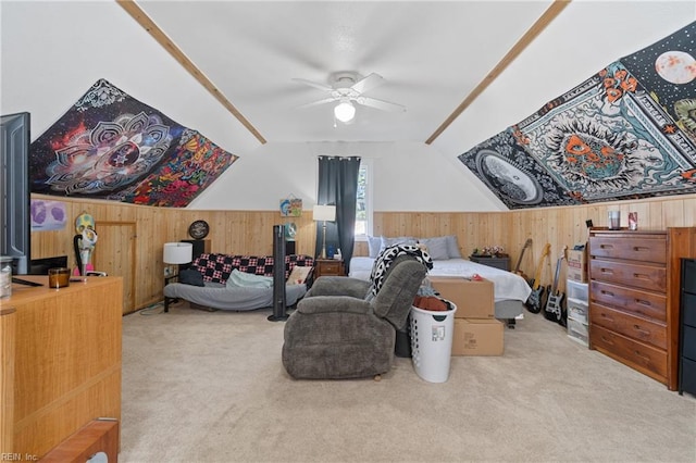 carpeted bedroom featuring ceiling fan, wood walls, and vaulted ceiling