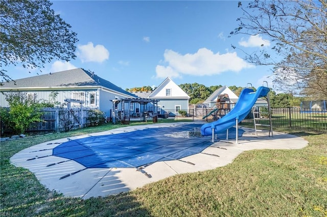 view of pool featuring a playground, a yard, and a water slide