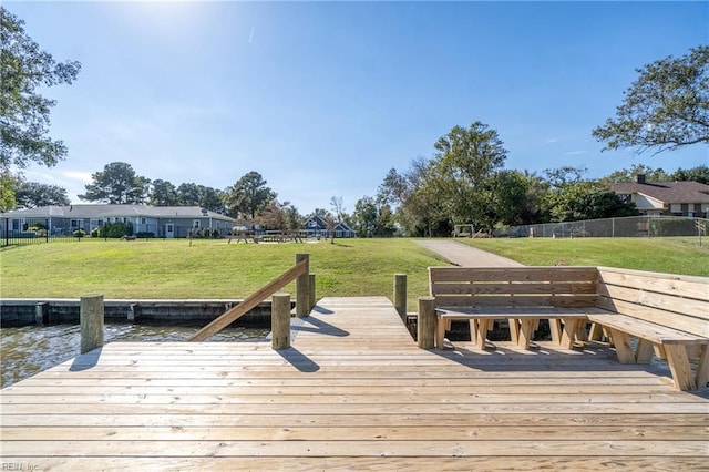 view of dock featuring a water view and a lawn