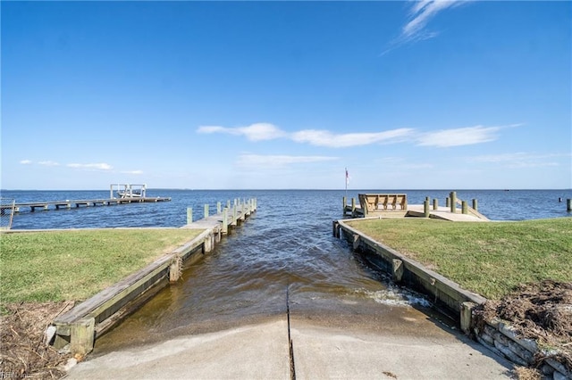 dock area featuring a lawn and a water view