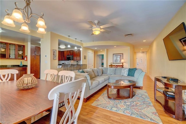 interior space featuring light hardwood / wood-style flooring and ceiling fan with notable chandelier