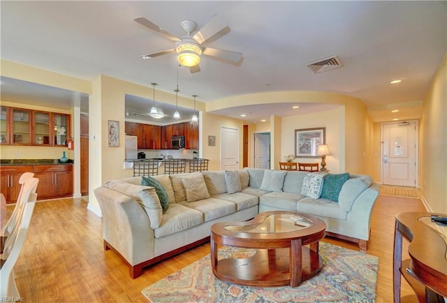 living room featuring light hardwood / wood-style floors and ceiling fan