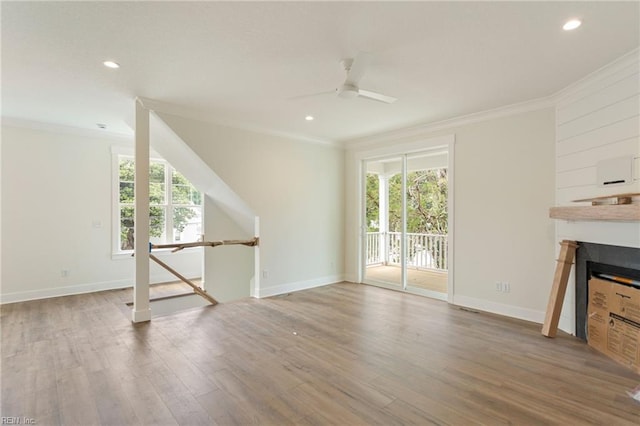 unfurnished living room with ceiling fan, ornamental molding, plenty of natural light, and hardwood / wood-style floors