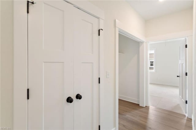 hallway with light hardwood / wood-style floors