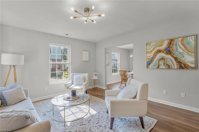 living room with hardwood / wood-style flooring, a healthy amount of sunlight, and a chandelier