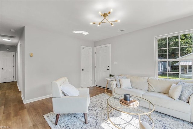 living room featuring wood-type flooring and a chandelier