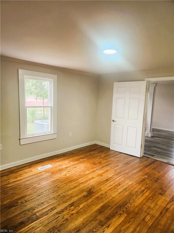 spare room with ornamental molding and hardwood / wood-style flooring