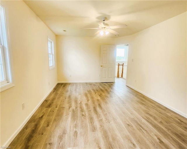 empty room with ceiling fan and light hardwood / wood-style floors