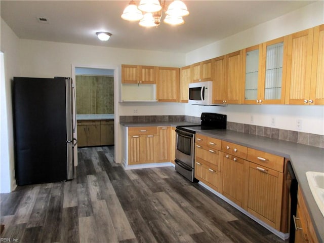 kitchen featuring stainless steel appliances, a chandelier, and dark wood-type flooring